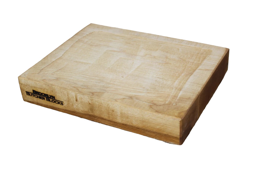 A rustic wooden serving board with a depressed center.